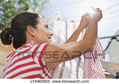 Stock Photography - Woman hanging clothes up on line. Fotosearch
