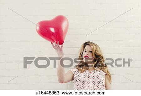 Woman holding heart shaped balloon View Large Photo Image Stock Image - Woman holding heart shaped balloon. Fotosearch