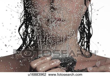 Stock Image - Woman holding shower head. Fotosearch