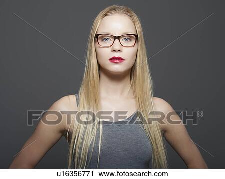 Woman in eyeglasses standing indoors View Large Photo Image Stock Image - Woman in eyeglasses standing indoors. Fotosearch