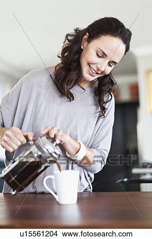 Picture - Woman making french press coffee. Fotosearch