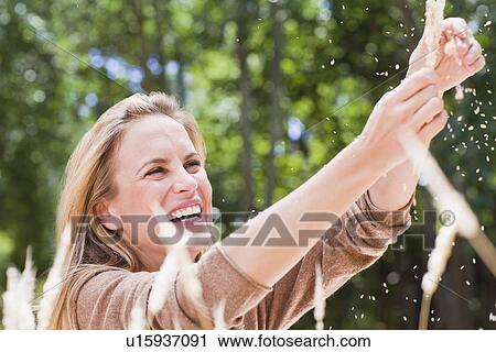 Woman playing with plants in park View Large Photo Image Stock Image - Woman playing with plants in park. Fotosearch