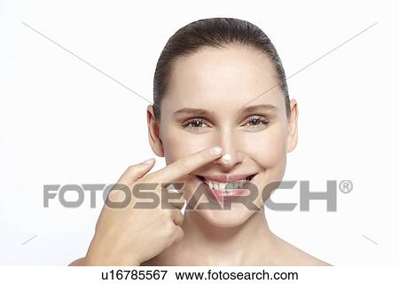 Stock Photo - Woman rubbing moisturizer on face. Fotosearch