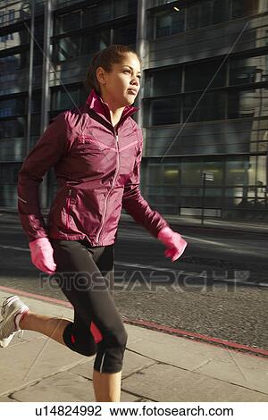 Woman running on city street View Large Photo Image Stock Image - Woman running on city street. Fotosearch