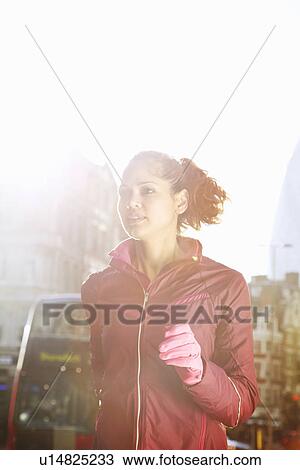 Stock Image - Woman running on city street. Fotosearch
