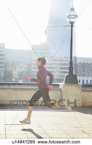 Woman running on urban bridge View Large Photo Image Stock Photo - Woman running on urban bridge. Fotosearch