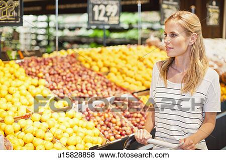 Stock Photo - Woman shopping in grocery store. Fotosearch