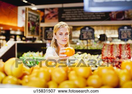 Woman shopping in grocery store View Large Photo Image Stock Photo - Woman shopping in grocery store. Fotosearch