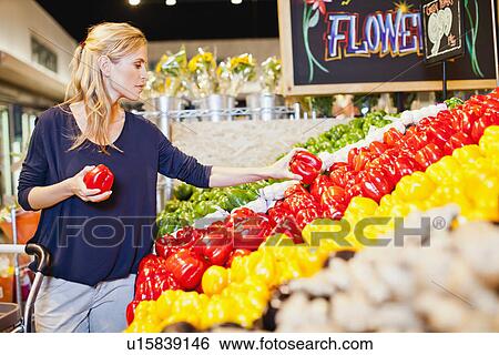 Stock Photograph - Woman shopping in grocery store. Fotosearch