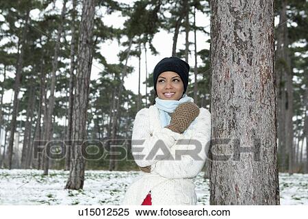 Stock Photography - Woman standing in snowy forest. Fotosearch