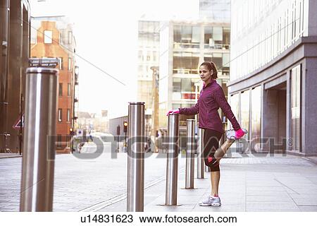 Woman stretching on city street View Large Photo Image Stock Image - Woman stretching on city street. Fotosearch