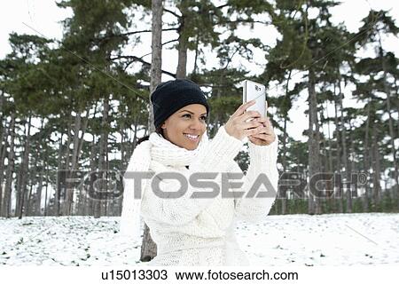 Woman taking picture in snowy forest View Large Photo Image Stock Image - Woman taking picture in snowy forest. Fotosearch