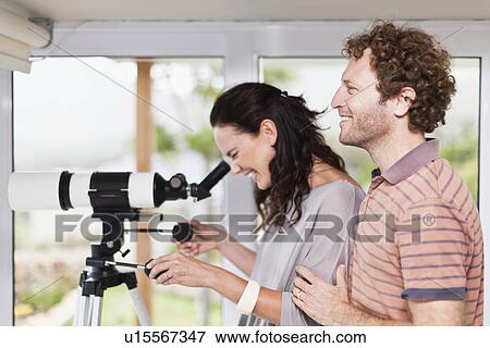 Stock Photo - Woman using boyfriends telescope. Fotosearch