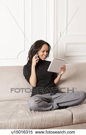 Stock Photography - Woman using tablet computer and cell phone. Fotosearch