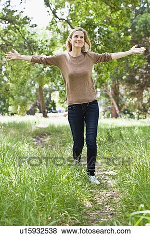 Stock Photo - Woman walking in park. Fotosearch