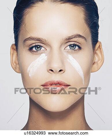 Stock Image - Woman with streaks of lotion on face. Fotosearch