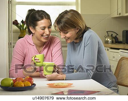 Women having coffee together in kitchen View Large Photo Image Stock Photo - Women having coffee together in kitchen. Fotosearch