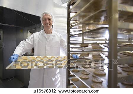Worker baking biscuits in factory View Large Photo Image Stock Image - Worker baking biscuits in factory. Fotosearch