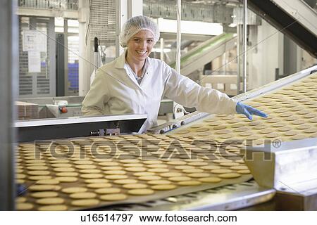 Stock Photo - Worker checking production line in factory. Fotosearch