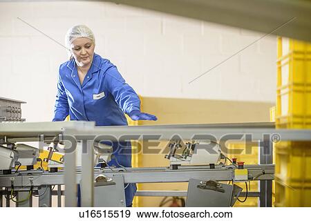 Stock Photo - Worker checking production line in factory. Fotosearch