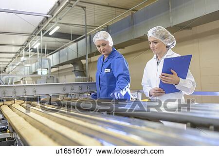 Stock Photo - Worker checking production line in factory. Fotosearch