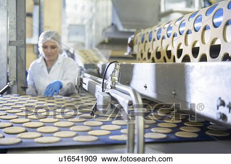 Stock Photo - Worker checking production line in factory. Fotosearch