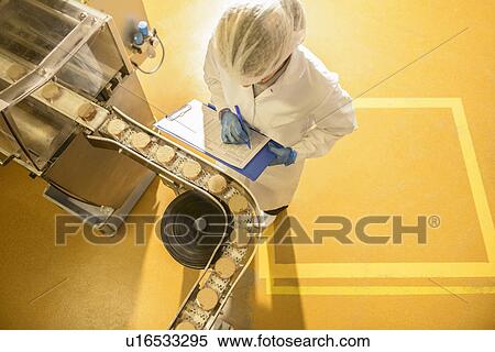 Stock Photography - Worker checking production line in factory. Fotosearch