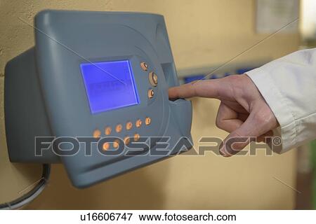 Stock Photo - Worker clocking in at factory. Fotosearch