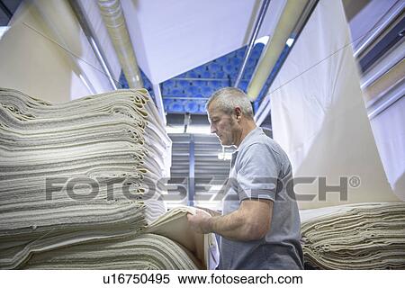 Worker examining fabric in textile mill View Large Photo Image Stock Photography - Worker examining fabric in textile mill. Fotosearch