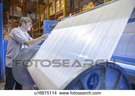Worker examining loom in textile mill View Large Photo Image Picture - Worker examining loom in textile mill. Fotosearch