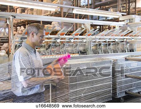 Worker examining loom in textile mill View Large Photo Image Stock Photo - Worker examining loom in textile mill. Fotosearch