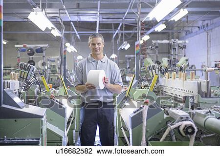 Worker holding thread in textile mill View Large Photo Image Stock Image - Worker holding thread in textile mill. Fotosearch