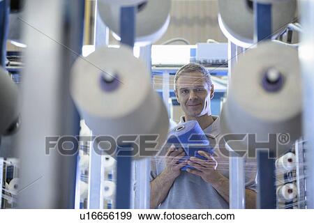 Worker holding thread in textile mill View Large Photo Image Stock Photo - Worker holding thread in textile mill. Fotosearch
