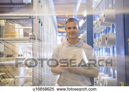 Stock Photography - Worker holding thread in textile mill. Fotosearch
