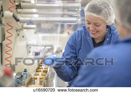 Stock Image - Worker packing in biscuit factory. Fotosearch
