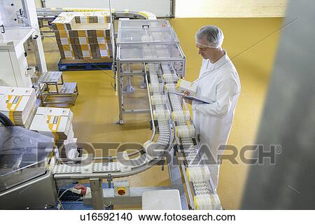 Worker packing in biscuit factory View Large Photo Image Stock Image - Worker packing in biscuit factory. Fotosearch
