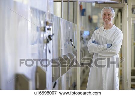 Stock Photo - Worker smiling in biscuit factory. Fotosearch