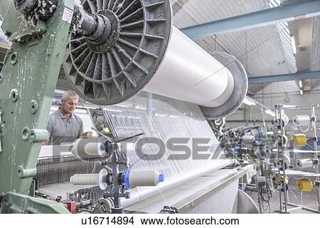 Worker using loom in textile mill View Large Photo Image Picture - Worker using loom in textile mill. Fotosearch
