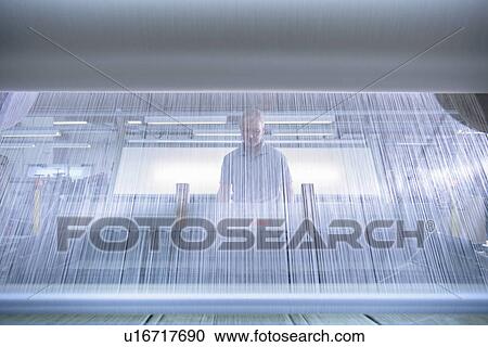 Worker using loom in textile mill View Large Photo Image Stock Image - Worker using loom in textile mill. Fotosearch
