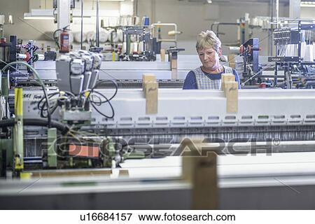 Worker using loom in textile mill View Large Photo Image Stock Photo - Worker using loom in textile mill. Fotosearch