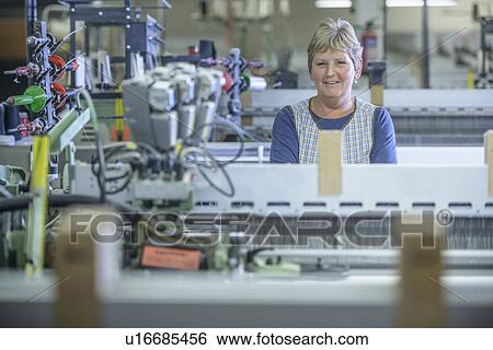 Worker using loom in textile mill View Large Photo Image Stock Photograph - Worker using loom in textile mill. Fotosearch
