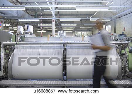 Stock Photo - Worker walking in textile mill. Fotosearch