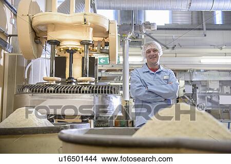 Picture - Worker with machinery in biscuit factory. Fotosearch