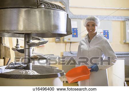 Stock Image - Worker with machinery in biscuit factory. Fotosearch