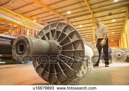 Worker with reel of yarn in textile mill View Large Photo Image Stock Image - Worker with reel of yarn in textile mill. Fotosearch