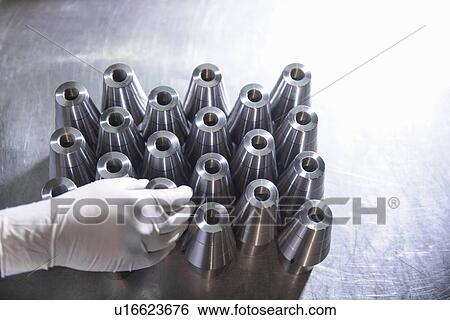 Stock Photograph - Worker with steel parts in factory. Fotosearch