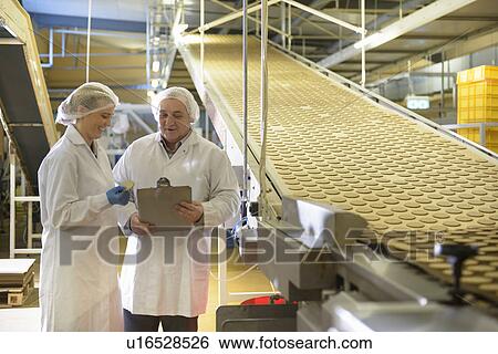 Stock Photograph - Workers talking in biscuit factory. Fotosearch