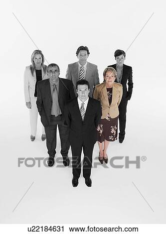 Stock Image - Ambitious businessman with team of professionals against white background. Fotosearch