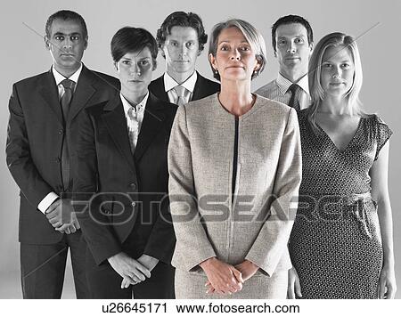 Ambitious businesswoman with team of professionals against gray background View Large Photo Image Stock Image - Ambitious businesswoman with team of professionals against gray background. Fotosearch