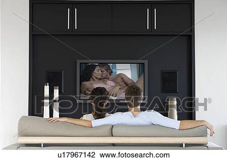 Back view of couple watching romantic movie on television in living room View Large Photo Image Stock Image - Back view of couple watching romantic movie on television in living room. Fotosearch